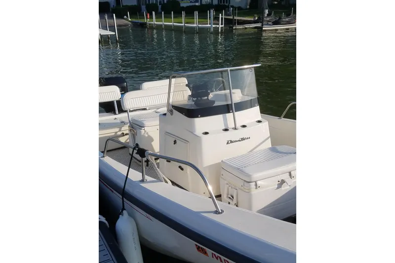 Slide: The Image of 1999 Boston Whaler 180 Dauntless boat docked by the water. - 15