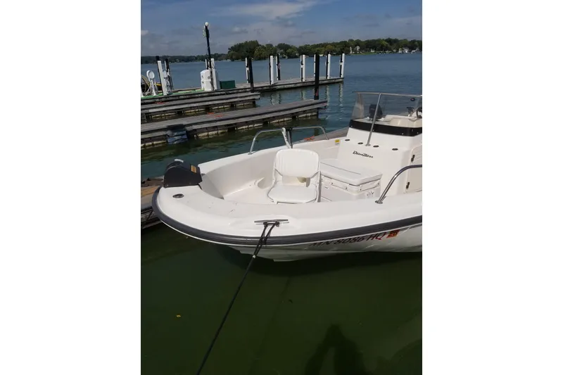 Slide: The Image of 1999 Boston Whaler 180 Dauntless boat docked on a calm lake. - 6