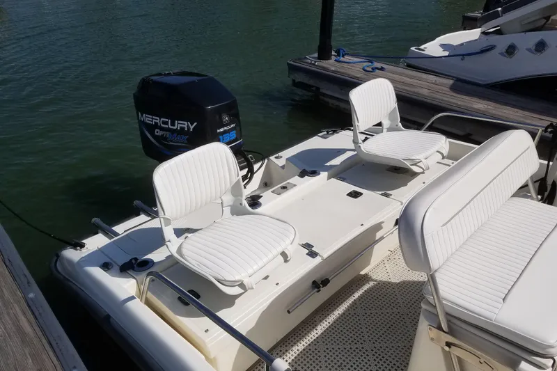 Slide: The Image of 1999 Boston Whaler 180 Dauntless boat with Mercury Optimax 135 engine, docked on water. - 7