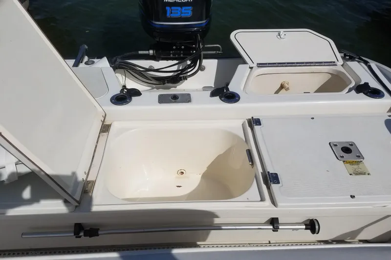 Slide: The Image of 1999 Boston Whaler 180 Dauntless boat interior with open storage compartments and Mercury 135 engine. - 9