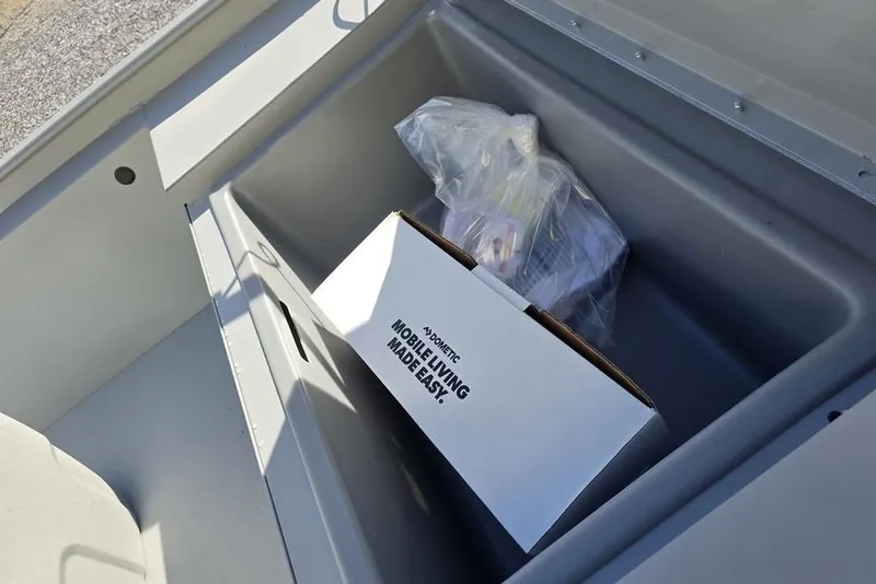 Slide: The Image of Storage compartment in 2026 Tracker Bass Tracker Classic CC boat with box and plastic bag. - 15