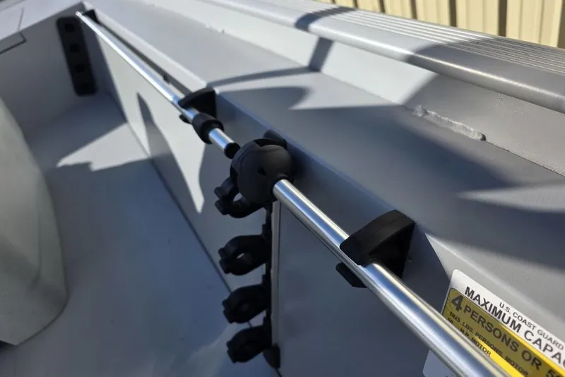 Slide: The Image of 2026 Tracker Bass Tracker Classic CC boat interior with rod holder and capacity label. - 3