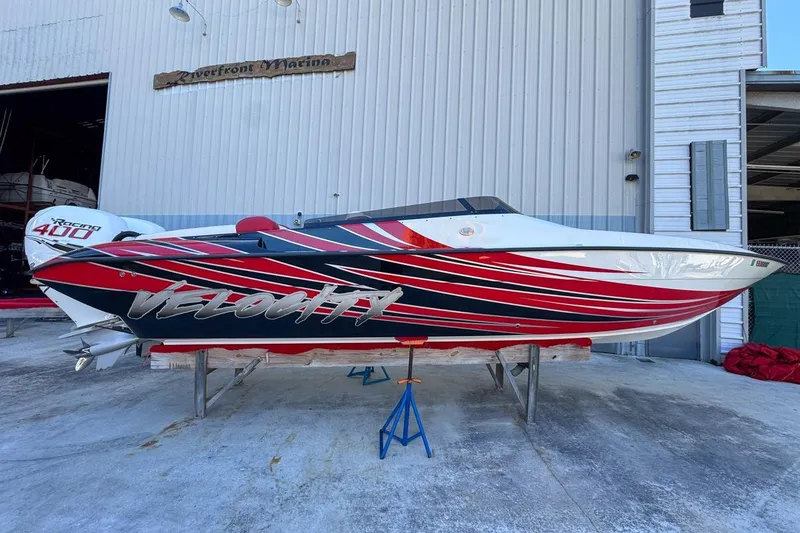 Slide: The Image of 2022 Velocity 290sc speedboat with vibrant red and black design at Riverfront Marina. - 10