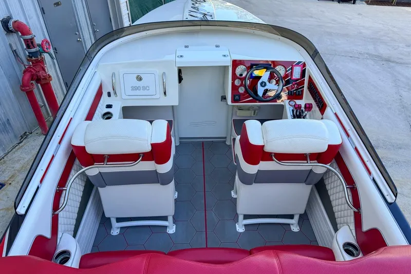 Slide: The Image of 2022 Velocity 290sc boat interior with red and white seating, modern dashboard, and hexagonal flooring. - 24