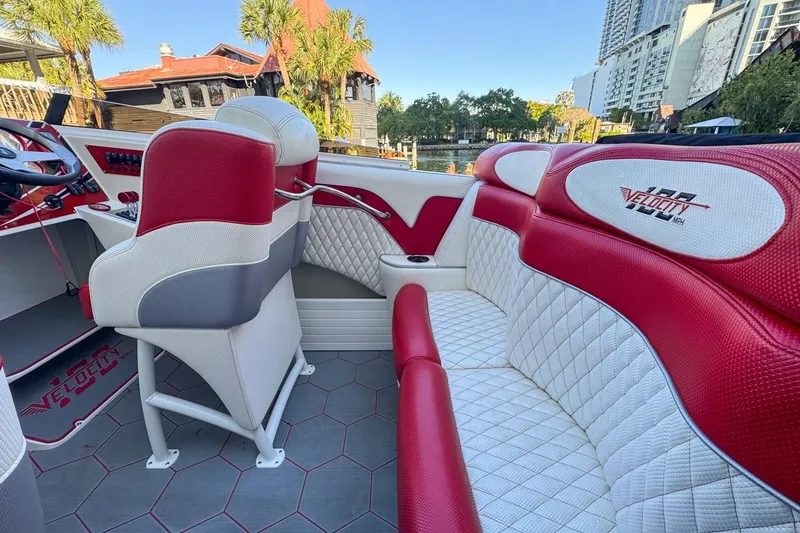Slide: The Image of Interior of 2022 Velocity 290sc boat with red and white seating, cityscape background. - 29