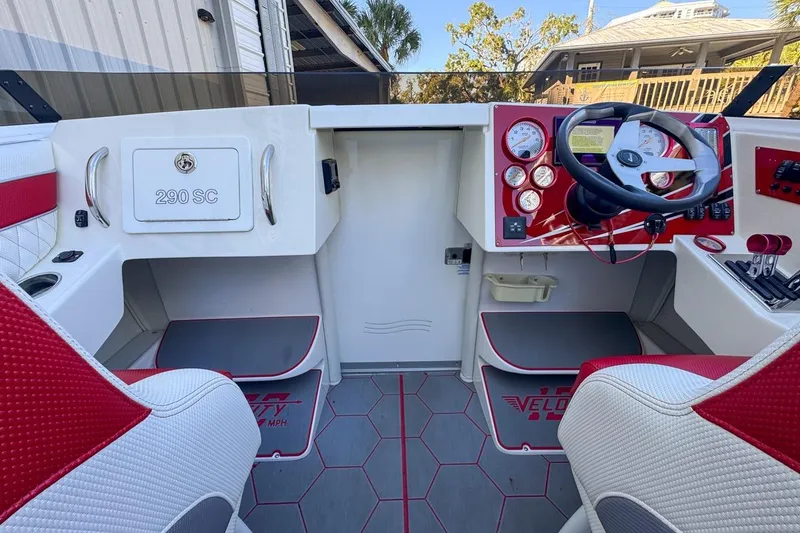 Slide: The Image of Interior of 2022 Velocity 290sc boat with red and white seating and control panel. - 39