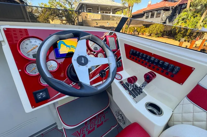 Slide: The Image of 2022 Velocity 290sc boat dashboard with red accents and navigation display. - 45
