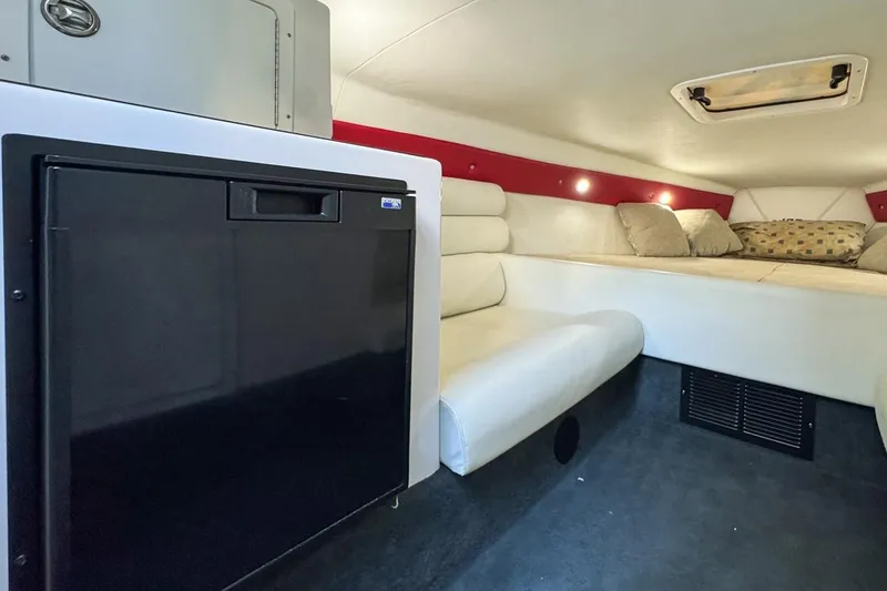 Slide: The Image of 2022 Velocity 290sc cabin interior with seating, bed, and compact refrigerator. - 56