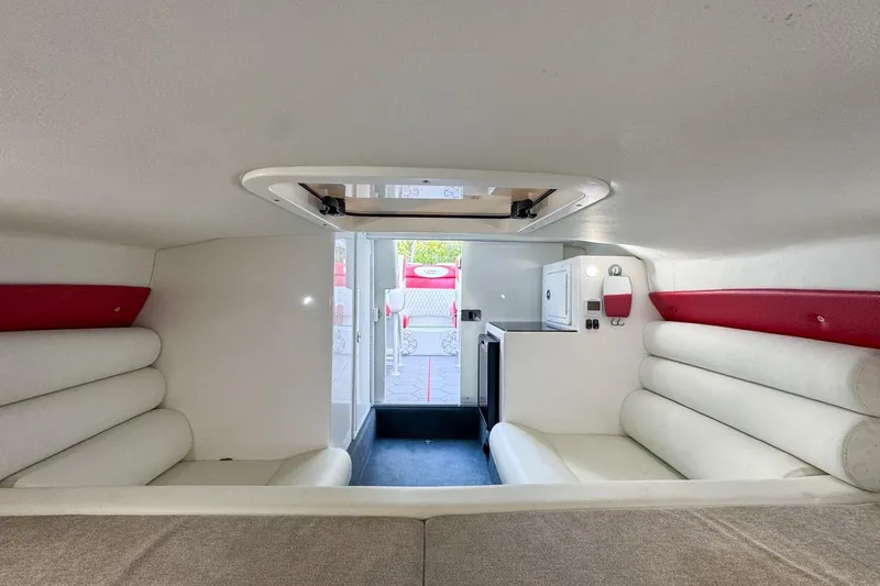 Slide: The Image of 2022 Velocity 290sc boat interior with white and red seating, compact kitchenette. - 69