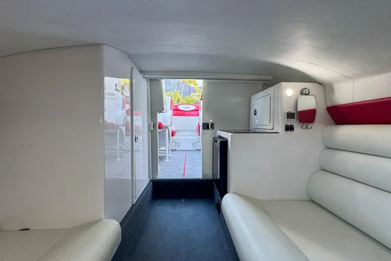 Slide: The Image of Interior of 2022 Velocity 290sc boat, featuring white seating and compact cabin amenities. - 71