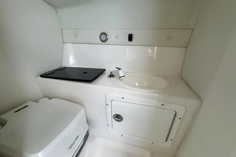 Slide: The Image of 2022 Velocity 290sc boat interior with sink and storage compartment. - 78