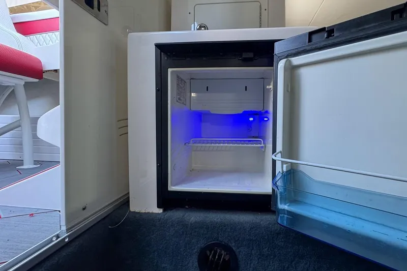 Slide: The Image of Open mini fridge with blue interior light in 2022 Velocity 290sc boat. - 84