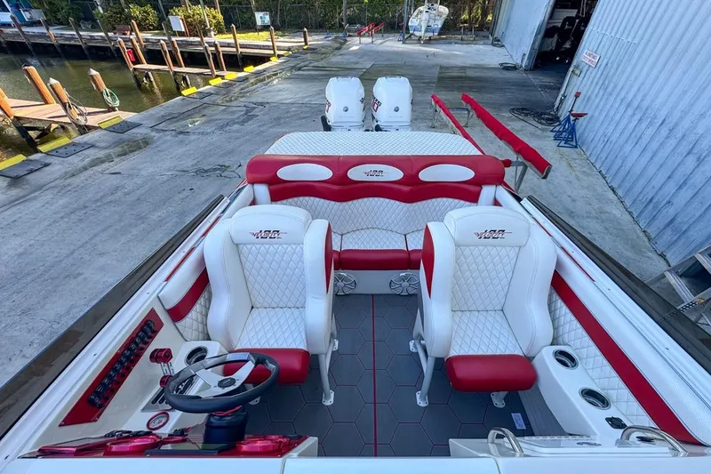 Slide: The Image of 2022 Velocity 290sc boat interior with red and white seating, docked at marina. - 87