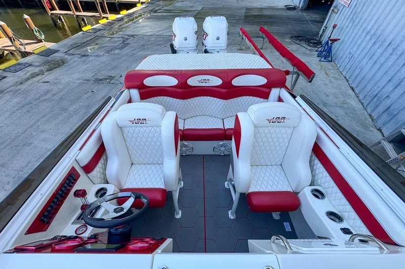 Slide: The Image of 2022 Velocity 290sc boat interior with red and white seating, docked at marina. - 88