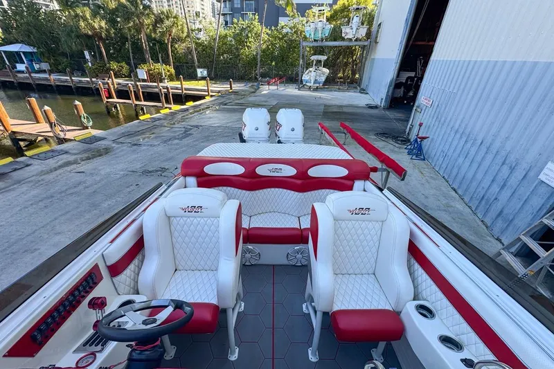 Slide: The Image of 2022 Velocity 290sc boat interior with red and white seating, dockside view. - 90