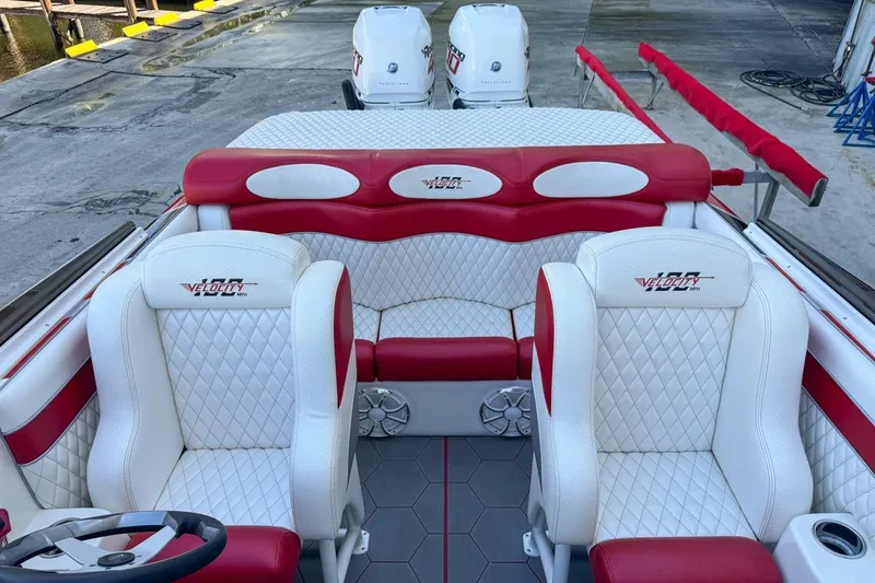 Slide: The Image of 2022 Velocity 290sc boat interior with red and white seating, docked at marina. - 91
