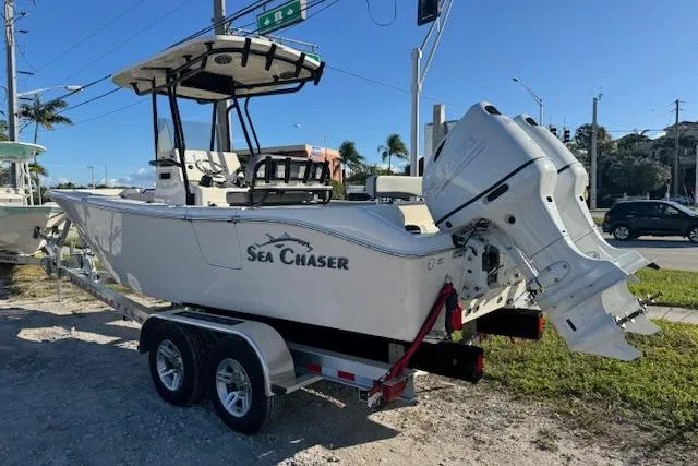 The Image of 2025 Sea Chaser 24 HFC boat on trailer, parked outdoors under clear sky. - 1