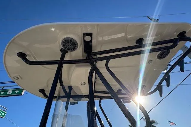 Slide: The Image of T-top of 2025 Sea Chaser 24 HFC boat with speakers, under clear blue sky. - 5