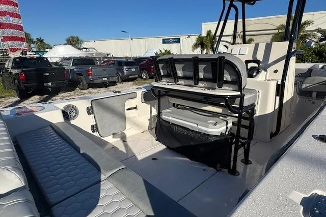 Slide: The Image of 2025 Sea Chaser 24 HFC boat interior with seating and storage, parked outdoors. - 9