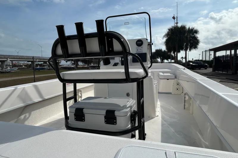 Slide: The Image of 2026 Sundance B20CCR boat interior with seating, rod holders, and console under a clear sky. - 13