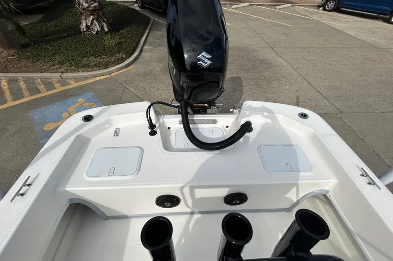 Slide: The Image of 2026 Sundance B20CCR boat with outboard motor in a parking area. - 14