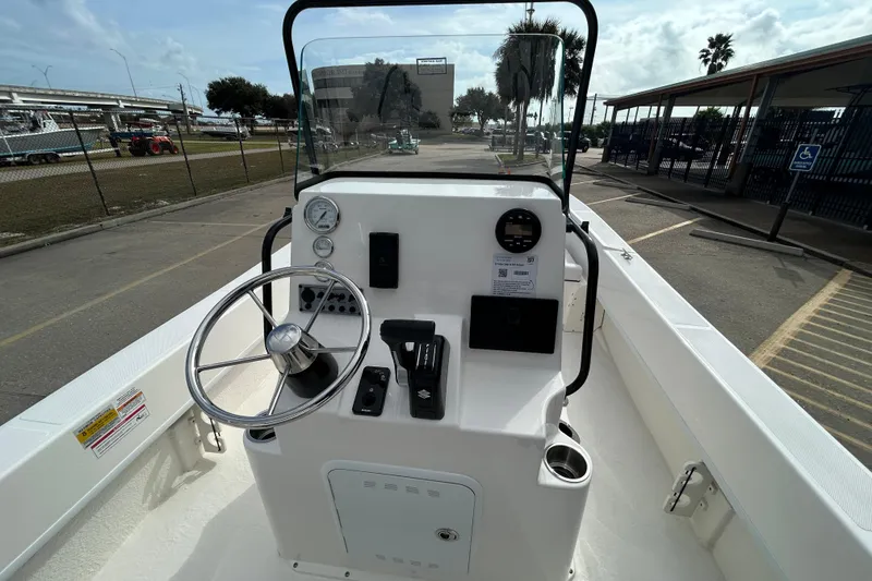 Slide: The Image of 2026 Sundance B20CCR boat console with steering wheel and controls, parked in a lot. - 16