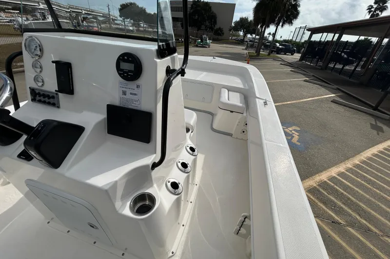 Slide: The Image of 2026 Sundance B20CCR boat interior with control panel and seating in a parking lot. - 17