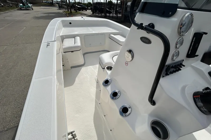 Slide: The Image of 2026 Sundance B20CCR boat interior with seating and control panel, docked outdoors. - 18