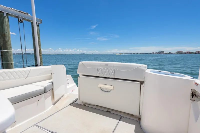 Slide: The Image of 2024 Regal 33 SAV boat interior with white seating, overlooking calm blue waters. - 12