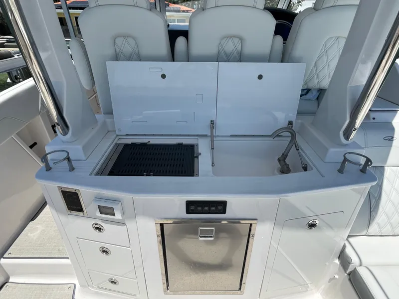 Slide: The Image of 2024 Regal 33 SAV boat interior with sink, grill, and storage compartments. - 15