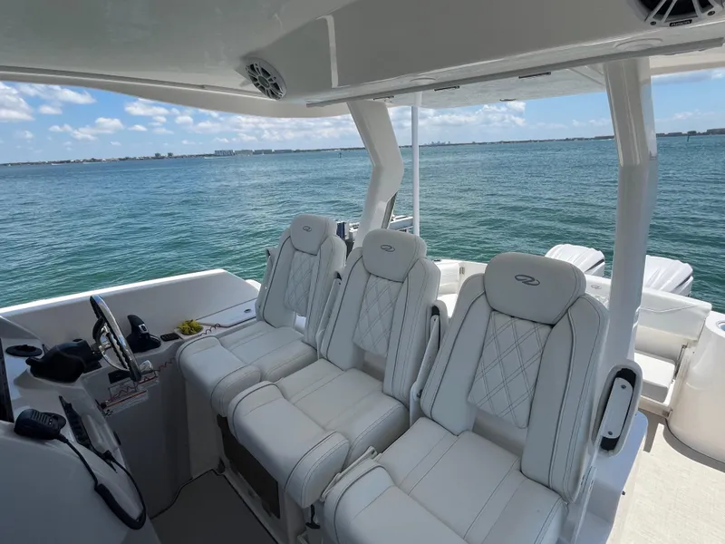 Slide: The Image of 2024 Regal 33 SAV boat interior with luxurious white seating and ocean view. - 19