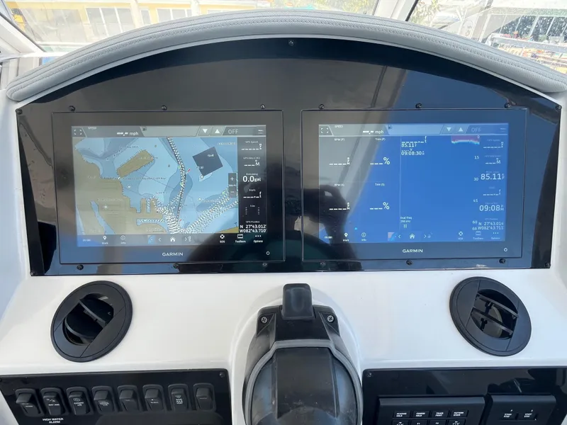 Slide: The Image of 2024 Regal 33 SAV dashboard with dual Garmin navigation screens displaying maps and data. - 21