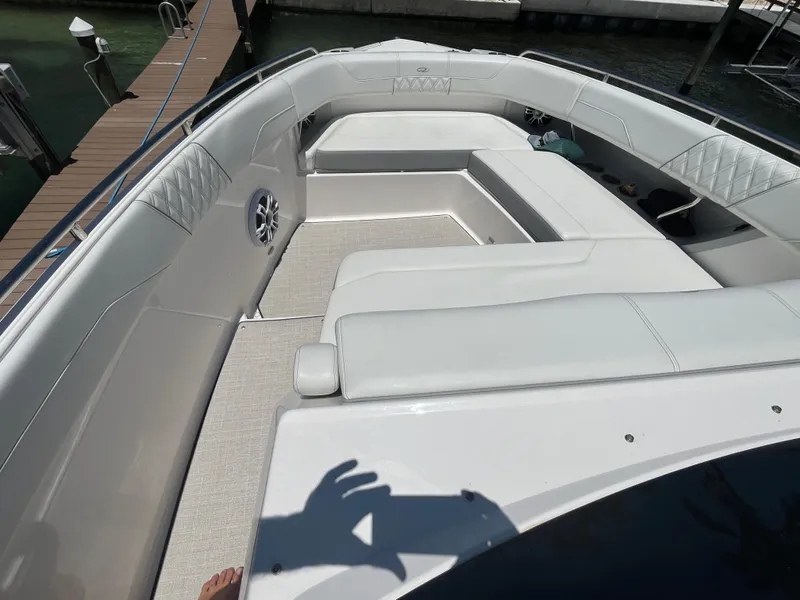 Slide: The Image of 2024 Regal 33 SAV boat with white seating, docked by the water. - 30