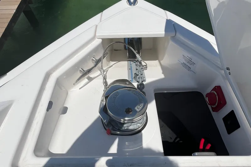 Slide: The Image of 2024 Regal 33 SAV boat interior with white seating, docked near waterfront homes. - 32