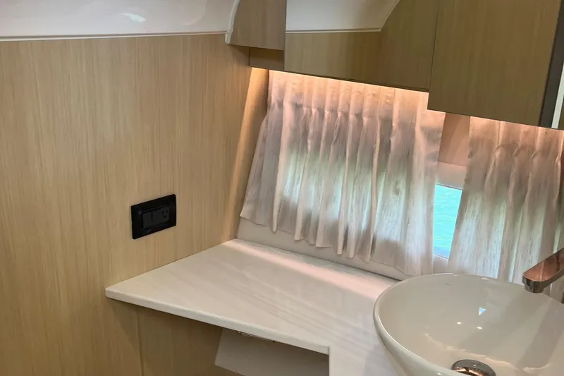 Slide: The Image of 2024 Regal 33 SAV bathroom with modern sink, wooden shelves, and elegant lighting. - 39