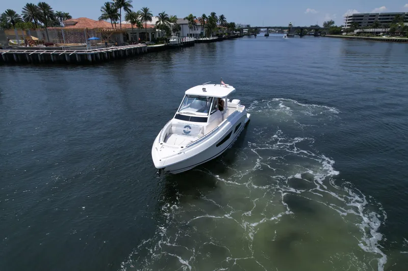 Slide: The Image of 2024 Regal 33 SAV boat cruising on a scenic waterway with palm trees. - 4