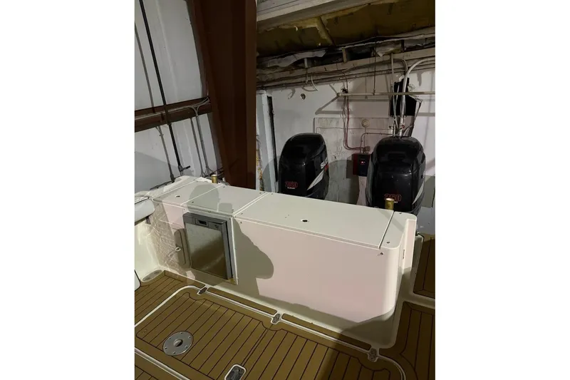 Slide: The Image of 2000 Pursuit 3070 Offshore Center Console with dual Suzuki outboard engines in storage. - 11
