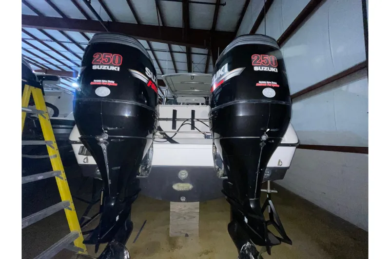 Slide: The Image of 2000 Pursuit 3070 Offshore Center Console with twin Suzuki 250 engines in storage. - 24