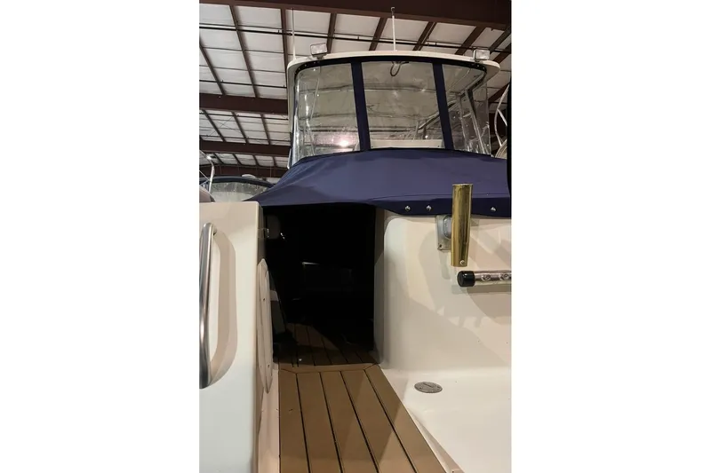 Slide: The Image of 2000 Pursuit 3070 Offshore Center Console boat with blue cover in storage. - 9