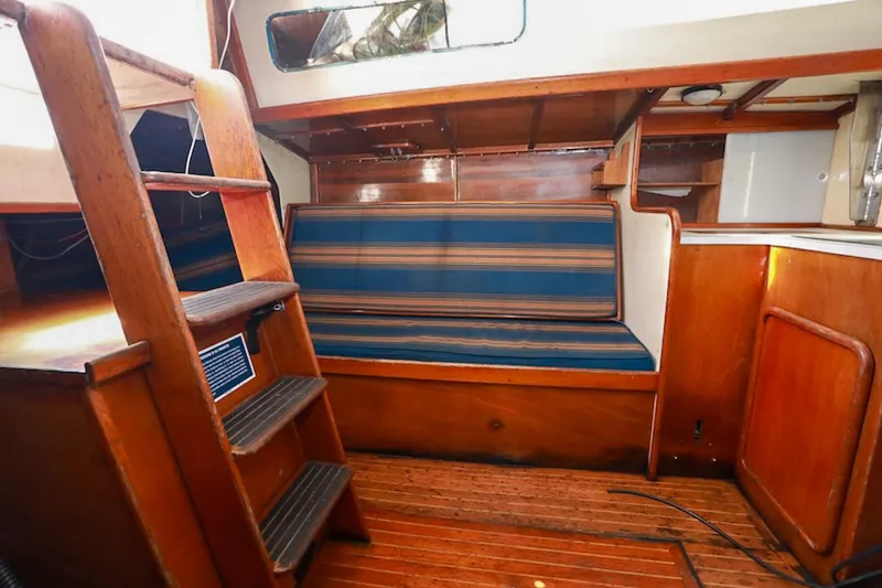 Slide: The Image of Interior of 1983 Nelson Marek 36 sailboat with wooden finish and striped seating. - 9
