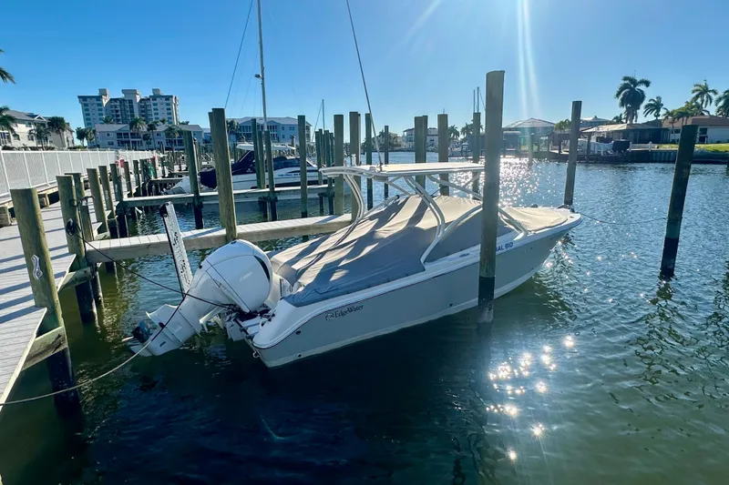 Slide: The Image of 2023 Edgewater 248CX Crossover boat docked in sunny marina setting. - 1