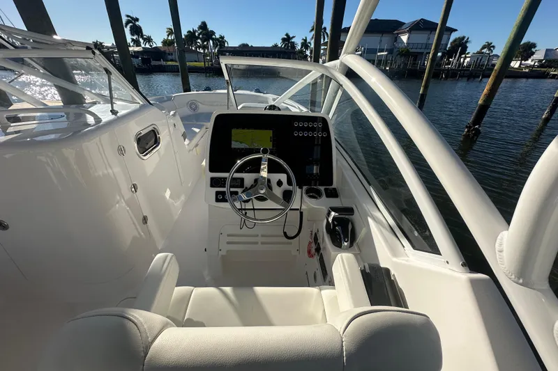 Slide: The Image of 2023 Edgewater 248CX Crossover boat cockpit with steering wheel and navigation display. - 12