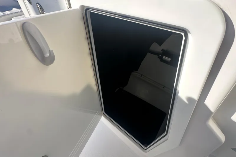 Slide: The Image of 2023 Edgewater 248CX Crossover boat storage compartment with open door. - 16