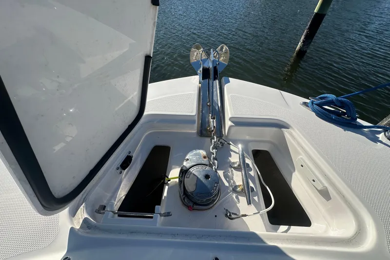Slide: The Image of Open anchor compartment on 2023 Edgewater 248CX Crossover boat, docked by water. - 18