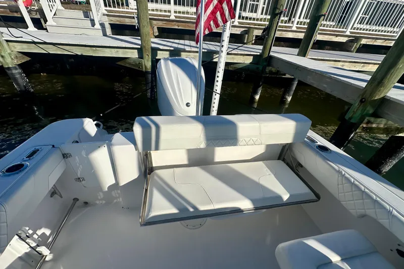 Slide: The Image of 2023 Edgewater 248CX Crossover boat interior with seating and dock view. - 5