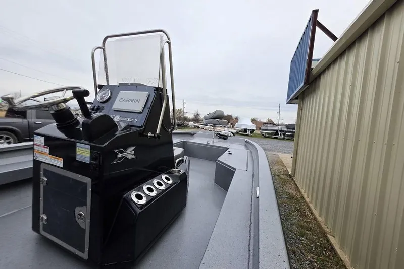 Slide: The Image of 2025 Xpress H22B Bay boat with Garmin system, parked beside a building. - 12