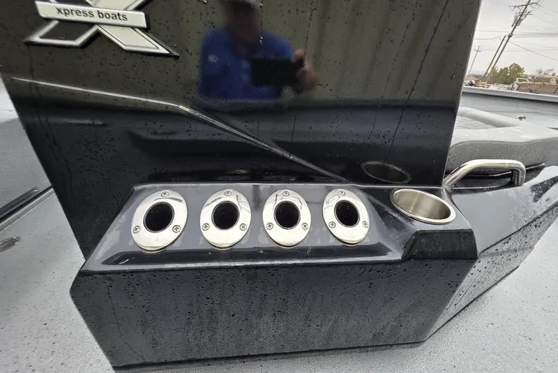Slide: The Image of 2025 Xpress H22B Bay boat with rod holders and cup holder on wet deck. - 14