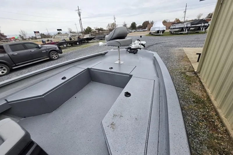 Slide: The Image of 2025 Xpress H22B Bay boat with seating, parked outdoors near vehicles. - 18