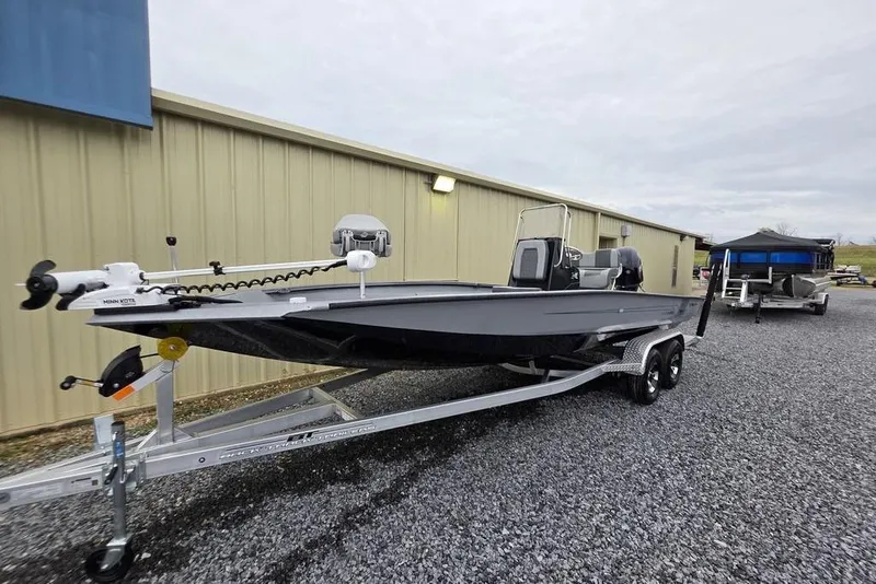 Slide: The Image of 2025 Xpress H22B Bay boat on trailer, parked outside a building. - 26
