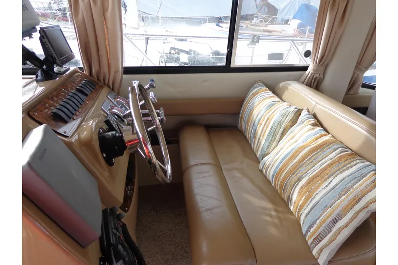 Slide: The Image of 2001 Bayliner 3488 Command Bridge Motoryacht interior with helm, leather seating, and striped cushions. - 39